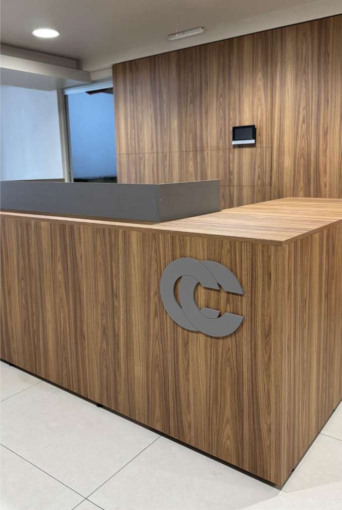 Recepción en madera con logo metálico integrado